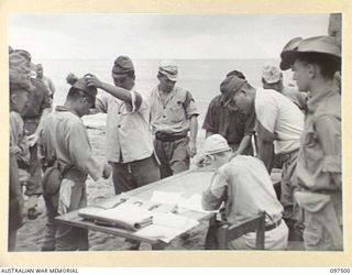 KAHILI, BOUGAINVILLE. 1945-10-01. AUSTRALIAN OFFICERS SUPERVISING ISSUING OF IDENTITY DISCS TO JAPANESE NAVAL TROOPS AT KAHILI BEACH. HIGH RANKING JAPANESE ARMY AND NAVAL OFFICERS WERE ESCORTED IN ..