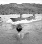 Boys in a canoe and swimming