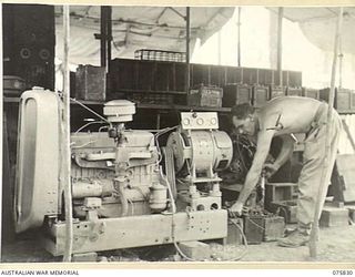 ALEXISHAFEN, NEW GUINEA. 1944-09-13. WX19657 CRAFTSMAN A. HANCOCK, 133RD WORKSHOP, OPERATING A CAPTURED JAPANESE BATTERY CHARGING UNIT WHICH HAS BEEN RECONDITIONED BY THE UNIT ELECTRICAL SECTION