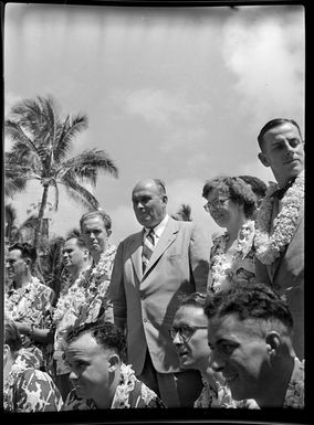 Group of men and women, wearing beach shirts and wreaths, Honolulu, Hawaii