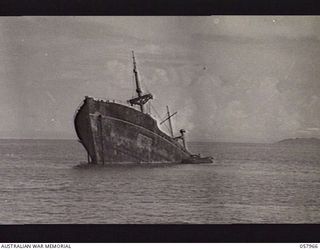 LAE, NEW GUINEA. 1943-10-04. THE BOW OF A JAPANESE SHIP SUNK IN SHALLOW WATER BY ALLIED BOMBER AIRCRAFT, PRIOR TO THE LANDING. NOTE THE AMPHIBIAN DUKW BESIDE THE WRECK