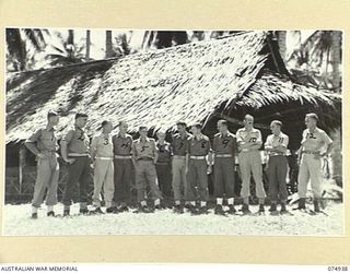 MILILAT, NEW GUINEA. 1944-07-17. OFFICERS OF HEADQUARTERS, 5TH DIVISION OUTSIDE THEIR MESS. IDENTIFIED PERSONNEL ARE:- VX39239 MAJOR C.E. SAWREY (1); NX133264 MAJOR D.R. ROBERTSON (2); QX35567 ..