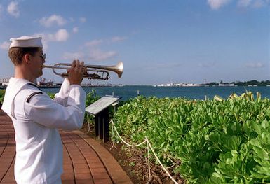 MU3 Gregg Dui, from US Navy Pacific Fleet band, performs Taps during the Pearl Harbor Commemoration ceremony, at the USS Arizona Memorial Visitor Center, Pearl Harbor, HI