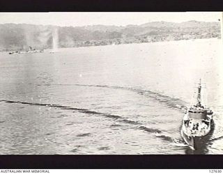 WEWAK, NEW GUINEA. 1944. SHIPPING IN HARBOUR UNDER ATTACK BY B25 BOMBER AIRCRAFT OF FIFTH AIR FORCE, UNITED STATES ARMY AIR FORCE. THE GUNBOAT IS TAKING EVASIVE ACTION WHILE THE CREW ARE TRYING TO ..
