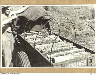 DUMPU, RAMU VALLEY, NEW GUINEA. 1943-11-24. VX36012 PRIVATE R. G. RINTOULE OF NHILL, VIC, OF THE 4TH AUSTRALIAN FIELD BAKERY DISPLAYS A LOAD OF FRESHLY BAKED BREAD WHICH HE IS DELIVERING TO UNITS ..