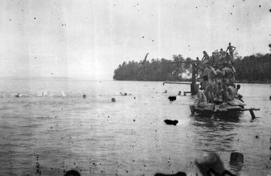 Men on wooden platform swimming and diving