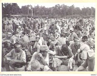 TOROKINA, BOUGAINVILLE. 1945-09-23. AUSTRALIAN TROOPS SURVEYING JAPANESE NAVAL TROOPS WHO ARE ON A 10-MILE MARCH FROM THE BUKA AREA, WHEN THEY WERE GIVEN A WELCOME REST AT THE GLOUCESTER PARK OVAL. ..