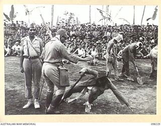 KARAVIA BAY, NEW BRITAIN. 1945-10-23. MAJOR GENERAL K.W. EATHER, GENERAL OFFICER COMMANDING 11 DIVISION, VISITED THE INDIAN EX-PRISONER OF WAR CAMP AT KARAVIA BAY. SHOWN, A SKETCH DEPICTING THE ..