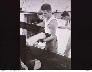 KILIGIA, NEW GUINEA. 1944-03-19. BAKERS OF THE 8TH FIELD BAKERY PLATOON REMOVING BREAD FROM THE TWO BROWN AND KIDD DOUBLE DECKER OVENS AT THE UNIT