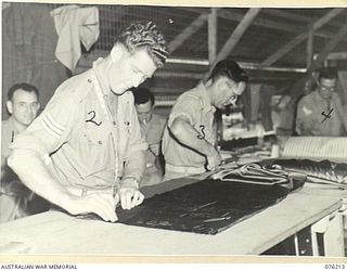 LAE, NEW GUINEA. 1944-09-28. CUTTERS AT WORK IN THE WORKROOM OF THE OFFICERS' SHOP, HEADQUARTERS NEW GUINEA FORCE. IDENTIFIED PERSONNEL ARE:- Q132327 CORPORAL W.A. SHEPHERD (1); NX122074 SERGEANT ..