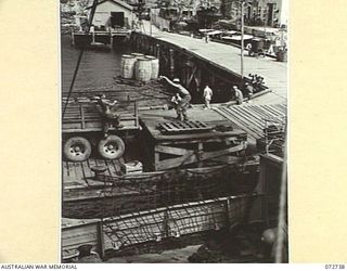 PORT MORESBY, NEW GUINEA. 1944-04-28. SUPPLIES BEING UNLOADED FROM THE STEAM SHIP MONTORO ON TO TRUCKS FOR TRANSPORTATION TO NO. 5 BASE SUPPLY DEPOT. THE DOCKS ARE OPERATED BY MEMBERS OF THE 2/1ST ..