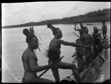 Eight men and boys standing in a canoe, Ramu River, New Guinea, 1935 / Sarah Chinnery