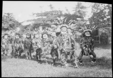Double row of decorated dancers with person on right legs apart, New Guinea, ca. 1929 / Sarah Chinnery