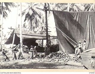 MILILAT, NEW GUINEA. 1944-09-12. PERSONNEL OF B SQUADRON, 2/4TH ARMOURED REGIMENT ERECTING LARGE CANVAS SHELTERS TO PROTECT THEIR TANKS FROM THE HEAVY TROPICAL RAINS