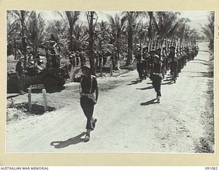 JACQUINOT BAY, NEW BRITAIN. 1945-04-21. BRIGADIER C.R.V. EDGAR, COMMANDER 4 INFANTRY BRIGADE (1), TAKES THE SALUTE FROM D COMPANY, 37/52 INFANTRY BATTALION DURING THE MARCH PAST