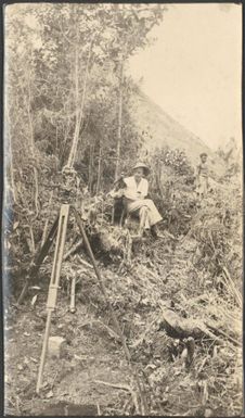 [Iris Spink is seated among the decomposed vegetation in the Edie Creek area holding a dog, Central New Guinea], October 1936