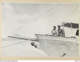 TOBOI WHARF, RABAUL, NEW BRITAIN. 1945-10-05. MAJOR GENERAL B.M. MORRIS, COMMANDER AUSTRALIAN NEW GUINEA ADMINISTRATIVE UNIT, AND MAJOR BATES STANDING ON THE BOW OF THE LAURABADA. MAJOR GENERAL ..