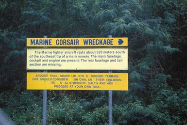 View along the Guam Historical Trail with a sign describing the wreckage of a World War II F-4U Corsair fighter aircraft that crashed on approach to the Orote Airfield main runway in 1944