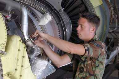 At Andersen Air Force Base (AFB), Guam (GU), US Air Force (USAF) SENIOR AIRMAN (SRA) Lester Smith, an engine mechanic from the 5th Bomb Wing (BW), Minot Air Force Base (AFB), North Dakota (ND), uses a safety wire to secure a quick disconnect line on a B-52 Stratofortress bomber aircraft engine during a maintenance inspection here