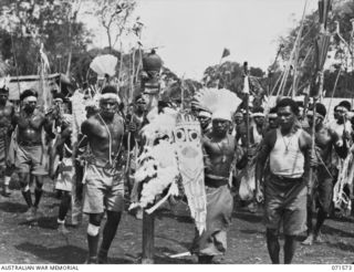 SONG RIVER, FINSCHHAFEN AREA, NEW GUINEA. 1944-03-26. MARKHAM RIVER BOYS DANCING AROUND A TOTEM POLE DURING A NATIVE SING-SING IN THE AUSTRALIAN NEW GUINEA ADMINISTRATIVE UNIT COMPOUND TO CELEBRATE ..