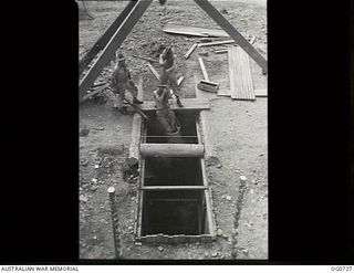 NADZAB, NEW GUINEA. C. 1944-02. AIRMEN OF NO. 62 MOBILE WORKS SQUADRON RAAF DIGGING A FIFTY FOOT WELL IN THE MARKHAM VALLEY TO SUPPLY THEIR CAMPS WITH WATER. AIRMEN ARE GOING DOWN IN THE BUCKET TO ..