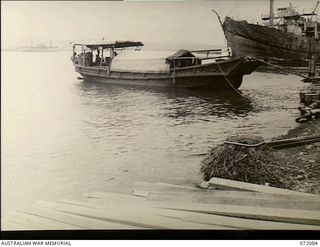 Milne Bay, New Guinea. 1944-04-06. A captured Japanese barge, marked AB588, being used as a cargo carrying vessel. Moored in the right background is the Motor Vessel Anshun which had been refloated ..