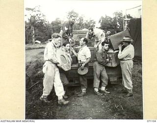 KILIGIA, NEW GUINEA, 1944-03-14. MEMBERS OF THE 3RD ARMOURED DIVISION CONCERT PARTY UNLOADING THEIR FEW BOXES OF "PROPS" TO ENTERTAIN TROOPS OF THE 5TH AUSTRALIAN DIVISION. THE "PROPS" CAN BE ..