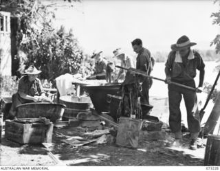 ALEXISHAFEN, NEW GUINEA. 1944-05. MEMBERS OF THE 2/15TH FIELD AMBULANCE MAKING USE OF ABANDONED JAPANESE RICE COOKING CAULDRONS TO WASH HOSPITAL LAUNDRY AT THEIR PRESENT CAMP SITE LOCATED IN THE ..