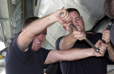 US Air Force (USAF) STAFF Sergeant (SSGT) John Beldin (left) and USAF SSGT Clayton Carver both Weapons Loaders assigned to the 2nd Bomb Wing (BW), make adjustments to a Conventional Air Launch Cruise Missile after loading it into the weapons bay of a USAF B-52H Stratofortress aircraft while deployed with the 7th Air Expeditionary Wing (AEW) at Andersen Air Force Base (AFB), Guam, during Operation ENDURING FREEDOM