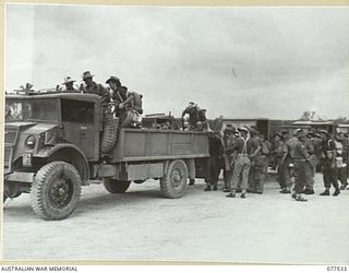 TOROKINA AREA, BOUGAINVILLE ISLAND. 1944-12-12. TROOPS OF THE 12TH ADVANCED WORKSHOPS BOARDING TRUCKS FOR THEIR JOURNEY TO THE DETAILS CAMP