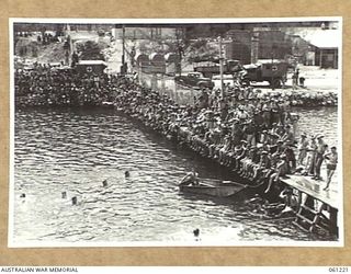 PORT MORESBY, NEW GUINEA. 1943-11-28. COMPETITORS WAITING FOR THE START OF THEIR RACES AT THE ALLIED SERVICES GRAND SWIMMING CARNIVAL