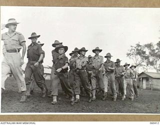 SOGERI, NEW GUINEA. 1943-11-20. STUDENTS MARCHING PAST THE OFFICER COMMANDING, SCHOOL OF SIGNALS, NEW GUINEA FORCE AS THEY MOVE OFF THE PARADE GROUND AFTER THE MORNING PARADE. SHOWN IS QX17881 ..