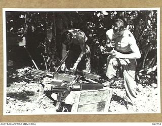 SX23158 CORPORAL D. P. MCCUSPIE (1) AND VX59410 SERGEANT H. DODD (2) ARMOURERS OF THE 1ST TANK BATTALION GROUP WORKSHOPS, AUSTRALIAN ELECTRICAL AND MECHANICAL ENGINEERS, OVERHAULING 7.92MM BESA ..