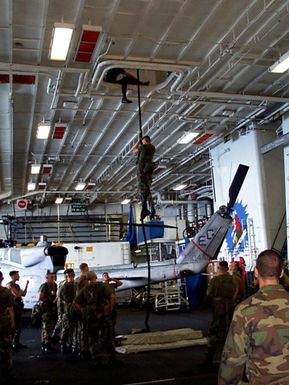 Special Operations Capable Marines from 24th Marine Expeditionary Unit (MEU) aboard USS GUAM (LPH 9) conduct Fast Rope training in the hangar bay. GUAM is in transit to the Persian Gulf in response to a U.S. Central Command request for an increased military presence in the region under Operation Southern Watch