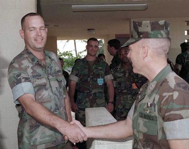 GUNNERY Sergeant C.S. Barnum of Combat Service Support Detachment-37, shakes hands with Commanding General Third Marine Expeditionary Force, General Wayne E. Rollings, during the general's visit to Tiyan, Guam, during Operation PACIFIC HAVEN. PACIFIC HAVEN provided Kurdish evacuees political asylum from Iraq. While on Guam, the Kurds are provided shelter, food, clothing, medical care and assimilation classes for life in the United States