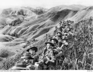 Far forward in the Finisterre Ranges, well on the way to Japanese held Bogadjim, these Australian troops, after a tough climb through the hills, pause for a breather. Identified, in the foreground, ..