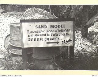 FINSCHHAFEN AREA, NEW GUINEA. 1944-03-17. ONE OF MANY BATTLE SIGNS IN THE AREA, THIS SIGN POINTS DIRECTION TO A SAND MODEL CONSTRUCTED TO DESCRIBE SATTELBERG TERRAIN TO TROOPS OF THE 2/48TH ..