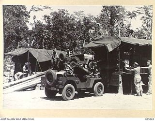 BOUGAINVILLE. 1945-08-30. TROOPS OF 113 BRIGADE WORKSHOP CORPS OF AUSTRALIAN ELECTRICAL AND MECHANICAL ENGINEERS CARRYING OUT REPAIRS ON VEHICLES. A JEEP IS BEING SERVICED ON THE RAMP AND A MOBILE ..