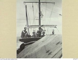 AT SEA. 1944-06-24. LIEUTENANT R.J.B. TRIMBLE (1), STOKER J. YATES (2) SIGNALMAN L. TOWNSEND (3) AND ABLE SEAMAN GLEDHILL (4) ALL OF THE ROYAL AUSTRALIAN NAVY, ON THE BRIDGE OF THE FAIRMILE ML431 ..