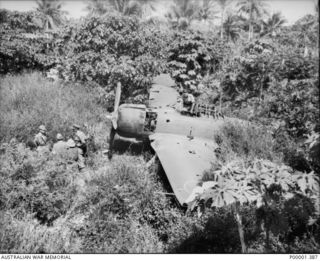 NEW IRELAND, 1945-10. DAMAGED JAPANESE A6M2 ZERO FIGHTER AIRCRAFT BEING INSPECTED BY ALLIED AND JAPANESE SERVICE PERSONNEL. (RNZAF OFFICIAL PHOTOGRAPH.)