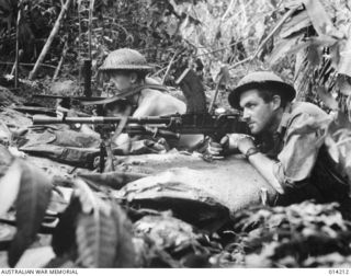 1943-01-25. PAPUA. SANANANDA AREA. SERGEANT S. CUMMING OF BRISBANE, QLD (LEFT), AND PRIVATE D. PAGE OF GRAFTON, NSW (SON OF SIR EARLE PAGE), BOTH MEMBERS OF 2/7TH CAVALRY REGIMENT, IN A FOX HOLE ..
