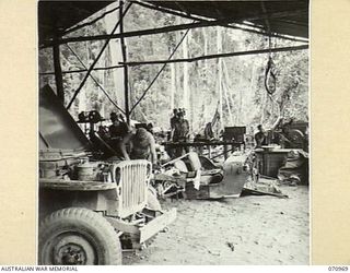 ZENAG, NEW GUINEA. 1944-02-28. THE NO. 2 SECTION, 8TH TRANSPORT WORKSHOPS, LOCATED 59 MILES FROM WAU, SHOWING THE LATHE TO THE LEFT OF THE PICTURE, PLANER TO THE RIGHT, AND JEEPS UNDERGOING ..