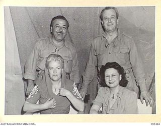 TOROKINA, BOUGAINVILLE, 1945-08-16. GRACIE FIELDS (1), WHO IS ENTERTAINING TROOPS AT HEADQUARTERS 2 CORPS WITH HER HUSBAND MR MONTY BANKS (3) AND MEMBERS OF HER CONCERT PARTY IN HER DRESSING ROOM. ..