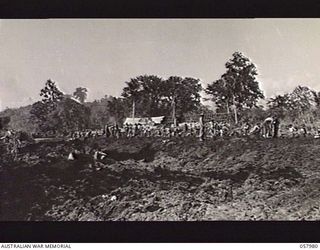 LAE, NEW GUINEA, 1043-10-12. A BUSY SCENE AS ENGINEERS OF THE 2/14TH AUSTRALIAN FIELD COMPANY WORK TO CLEAN UP A MUDDY SECTION OF ROAD, NEAR THE 5TH AUSTRALIAN DIVISION HEADQUARTERS