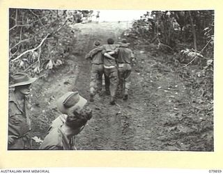 WAITAVALO AREA, WIDE BAY, NEW BRITAIN. 1945-03-16. WOUNDED OF THE 14/32ND INFANTRY BATTALION RECEIVE ASSISTANCE TOWARDS LCM'S (LANDING CRAFT MECHANIZED) FOR ONWARD EVACUATION AFTER RECEIVING ..