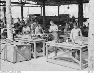LAE, NEW GUINEA. 1944-03-24. MEMBERS OF THE 2/7TH ADVANCED WORKSHOP ATTACHED TO THE AUSTRALIAN FORTRESS WORKSHOP WORKING IN THE RE-CONDITIONING SECTION. THE MOTOR TRANSPORT REPAIR SECTION IS ..