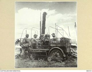 HANSA BAY, NEW GUINEA. 1944-07-10. MEMBERS OF THE 5TH DIVISION SALVAGE GROUP EXAMINE AN ABANDONED JAPANESE 75MM ANTI-AIRCRAFT PREDICTOR VEHICLE EQUIPPED WITH PREDICTOR, GENERATING PLANT AND ..