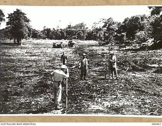 FINSCHHAFEN AREA, NEW GUINEA. 1943-11-09. SURVEYORS OF THE 808TH UNITED STATES ENGINEER AVIATION BATTALION AND THE 60TH UNITED STATES NAVAL CONSTRUCTION BATTALION, SURVEYING THE LEVELS FOR A NEW ..