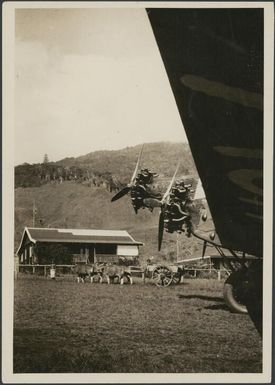 Bullock cart viewed from under a Fokker plane wing, Wau airfield, New Guinea, 1933 / Sarah Chinnery