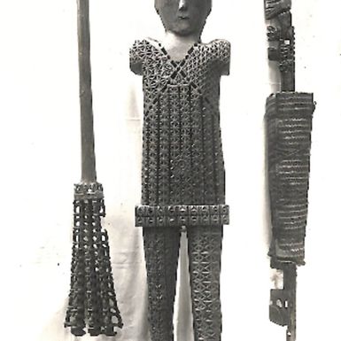 Photo of carved wooden male figure with 2 long wooden pieces (LXIII/18)